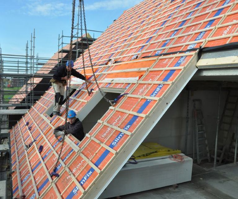 Projectfoto van een SlimFix XT Prefab daksegment met een dakraamvoorziening die wordt geplaatst.