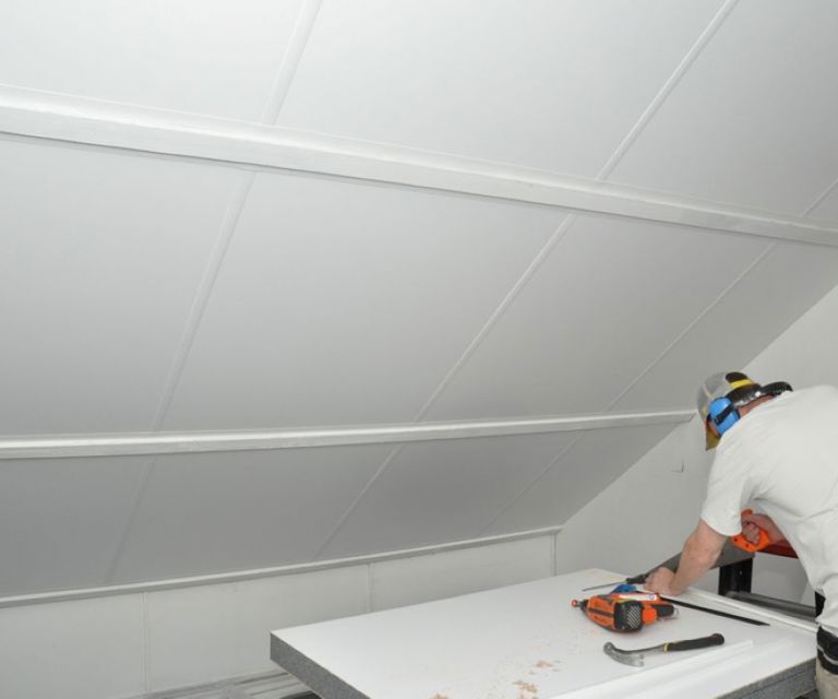 Projectfoto van een man die een SlimFix Deco zolderisolatieplaat op maat maakt.