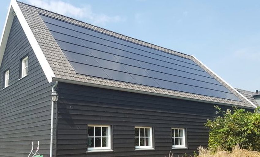 Foto van een woning waarbij de zonnepanelen verwerkt zijn in het dak omringt met dakpannen. 