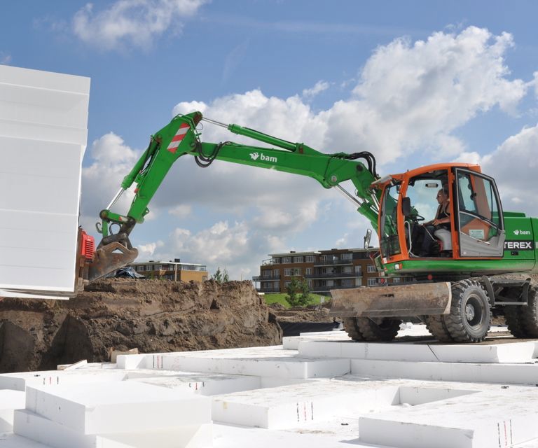 Projectfoto van een stapel PowerBlok funderingsblokken die met een graafmachine worden geplaatst.