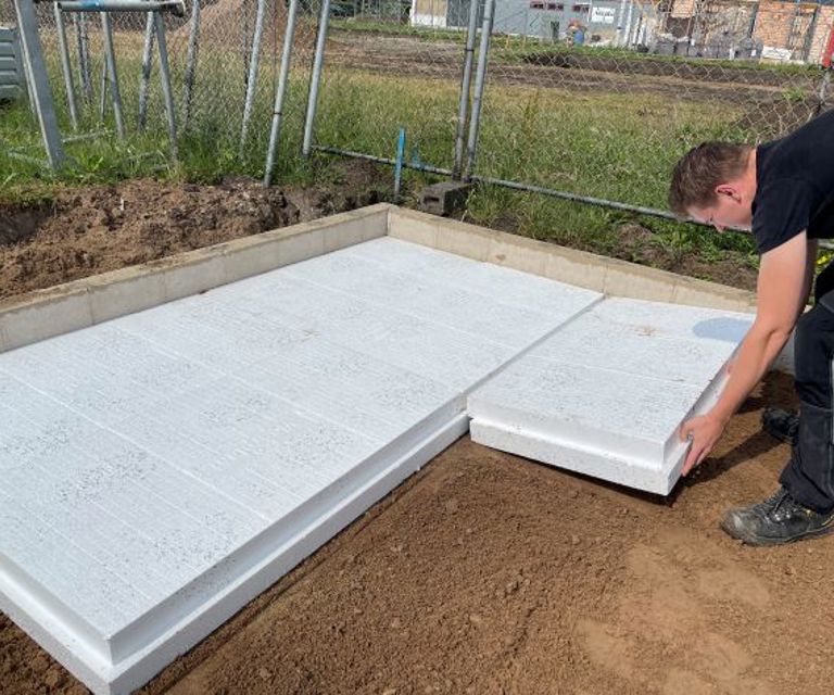 Projectfoto van een verwerker die een Eco vloerplaat legt op een bouwplaats.