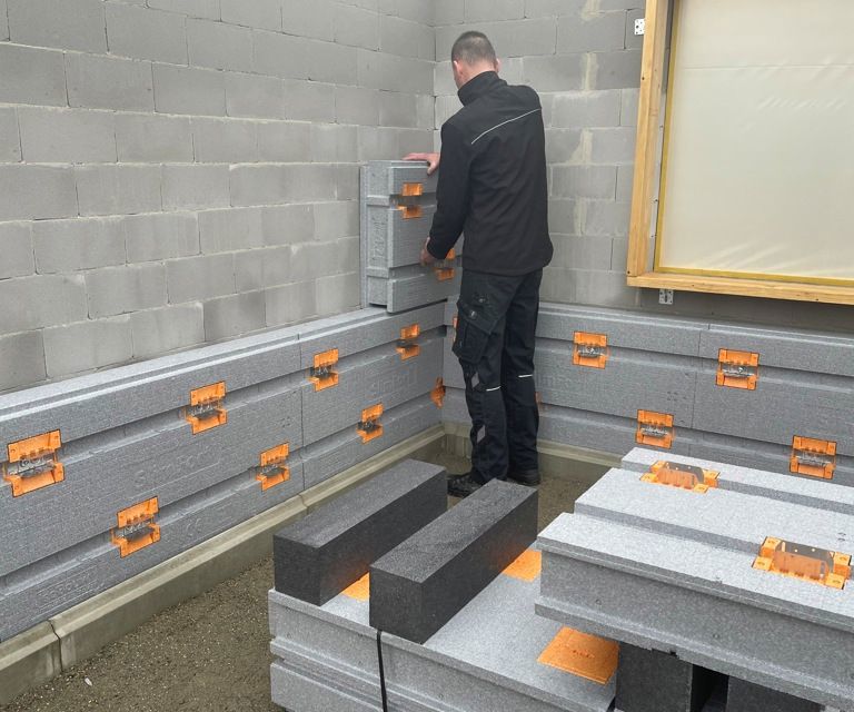 Projectfoto van een verwerker die een SlimFort gevelisolatieplaat plaatst tegen de bestaande muur.