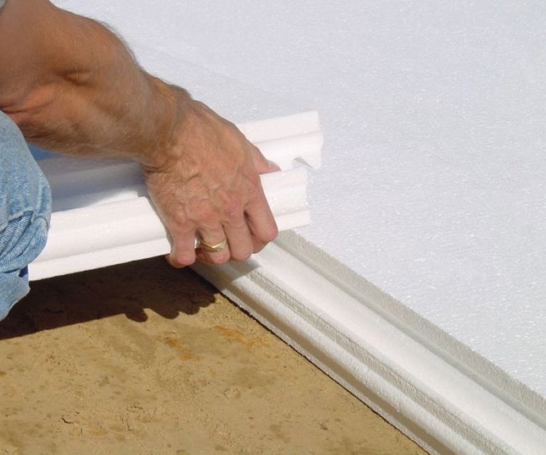 Close-up van het plaatsen van een IsoBouw Klik-vloerplaat in de randafwerking van andere vloerplaten.