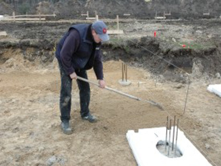 Projectfoto van stap 1 waar een verwerker de grond egaliseert voor het plaatsen van een bodemplaat.