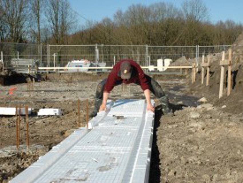 Projectfoto van stap 3 waar een verwerker de rechte bodemplaten van de PowerKist plaatst.