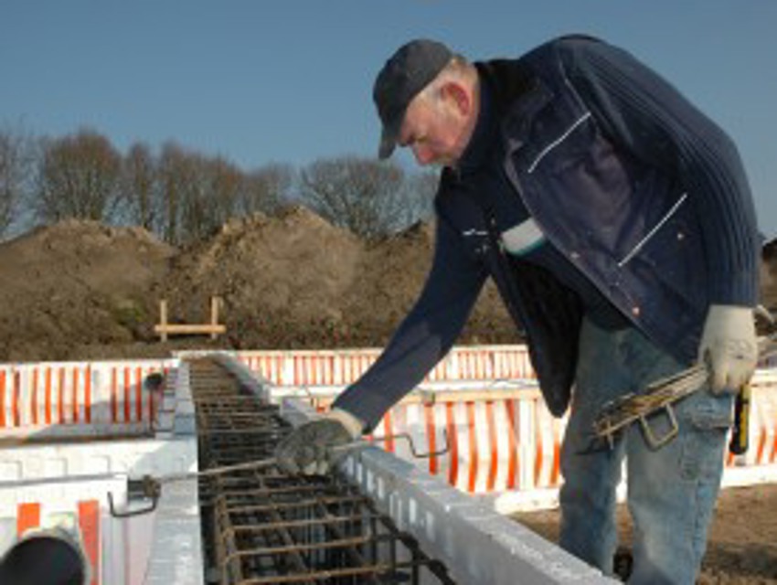 Projectfoto van stap 7 waar een verwerker een bovenbeugel aanbrengt op de PowerKist zijwanden.