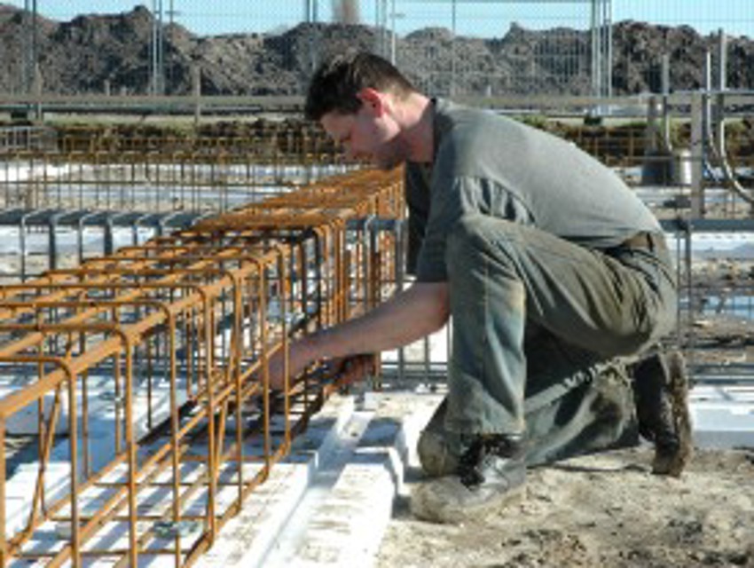 Projectfoto van stap 4 van een verwerker die de wapening plaatst op de bodemplaat van de PowerKist.