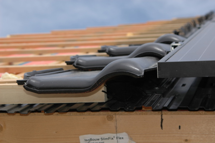 Projectfoto vanuit de gootzijde gemaakt, met dakisolatie, zonnepanelen en dakpannen zichtbaar.