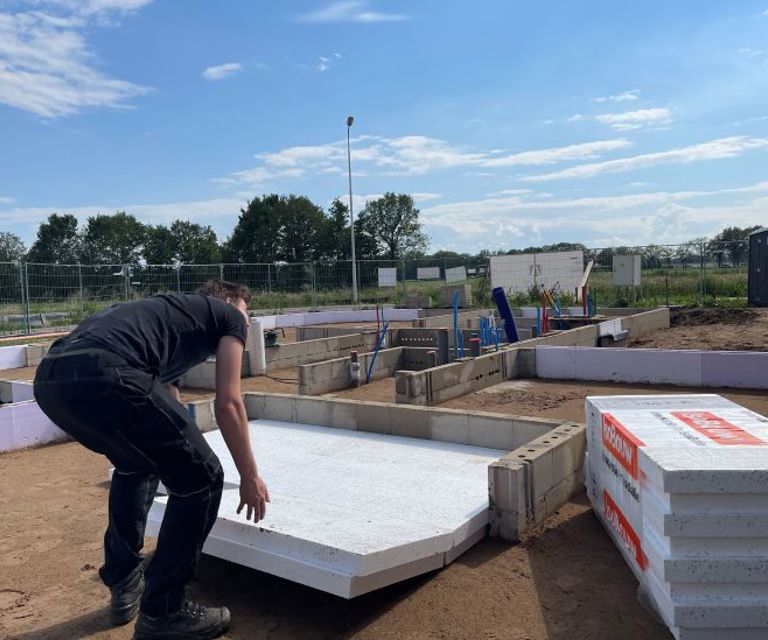 Projectfoto van een verwerker die een Eco vloerplaat legt op een bouwplaats.