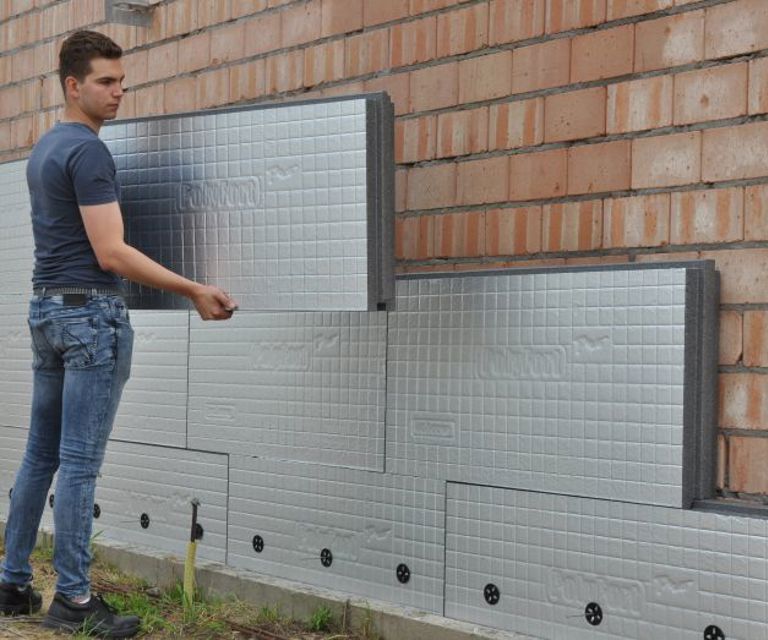 Projectfoto van een verwerker die een PolyFort Pro spouwisolatieplaat tegen het binnenblad plaatst.