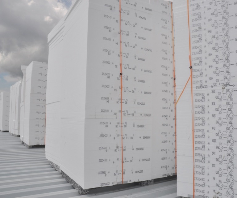 Projectfoto van een stapel witte EPS isolatieplaten van BEWI IsoBouw op het dak van een gebouw.