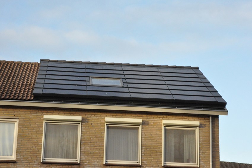 Foto van een tweekapper waarvan 1 woning het dak vernieuwd heeft inclusief solar panelen. 