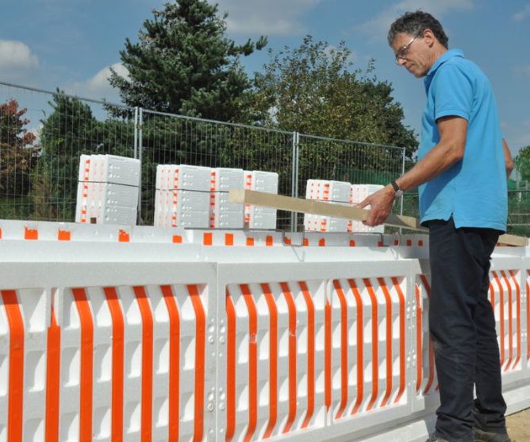 Projectfoto van een verwerker die een houten rib plaatst in de bovenbeugel van PowerKist bekisting.