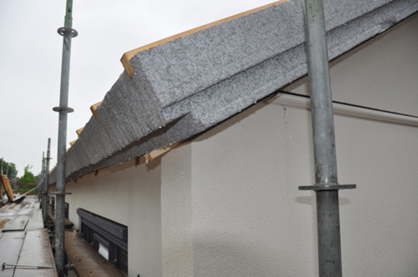 Projectfoto en close-up van de zijkant van een SlimFix RenoTwin dakplaat overstek.