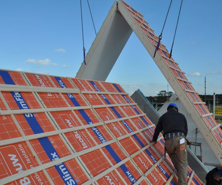 Projectfoto van een SlimFix XT Prefab daksegment die met een hijskraan wordt geplaatst.