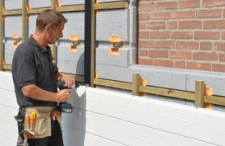 Projectfoto van stap 3 is het bevestigen van de afwerking op het houten raamwerk van SlimFort isolatie.