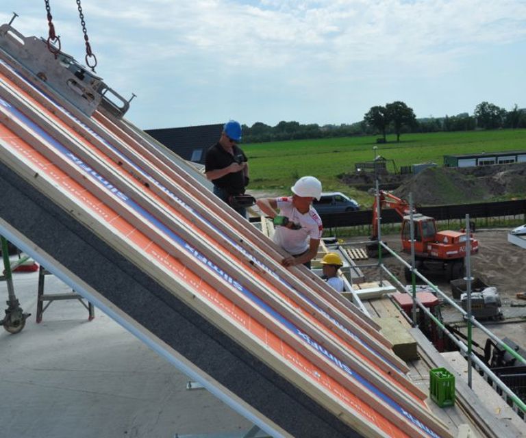 Projectfoto van de zijkant van Passief M dakplaten die gelegd worden door dakdekkers.