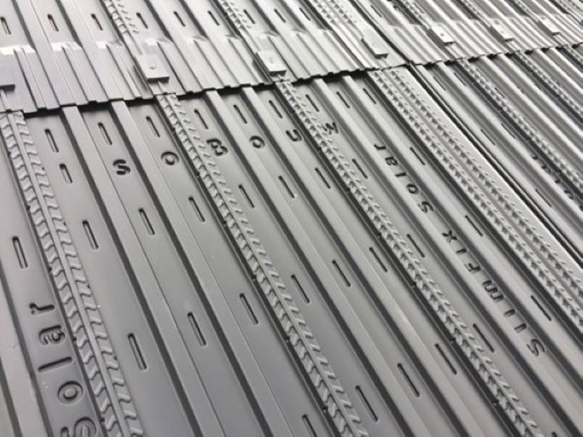 Close-up van gemonteerde zwarte solarmodules op een hellend dak. 