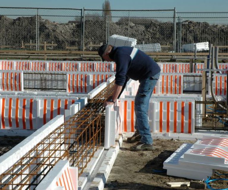 Projectfoto van een verwerker die een zijwand plaatst in de PowerKist funderingsbekisting.