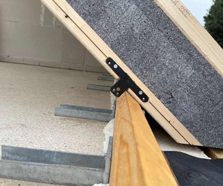 Projectfoto van een SlimFix XT Max dakelement waar de afschuifbeugel op de muurplaat wordt geplaatst. 