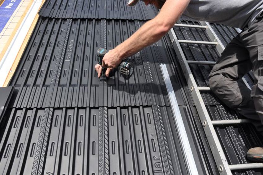 Projectfoto waarbij een persoon een solar module met een schroef bevestigd. 