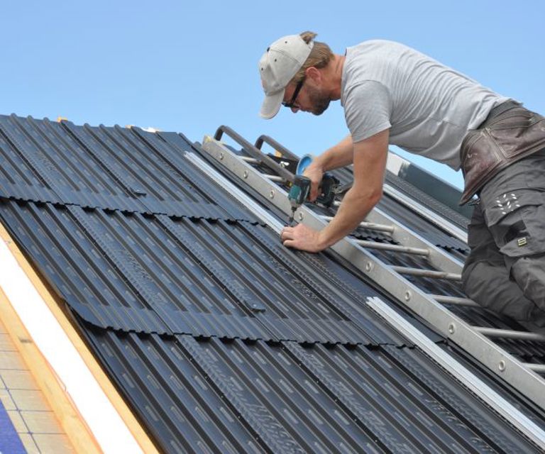 Projectfoto waarbij een dakdekker een solar module bevestigd op een SlimFix RenoTwin dakelement.