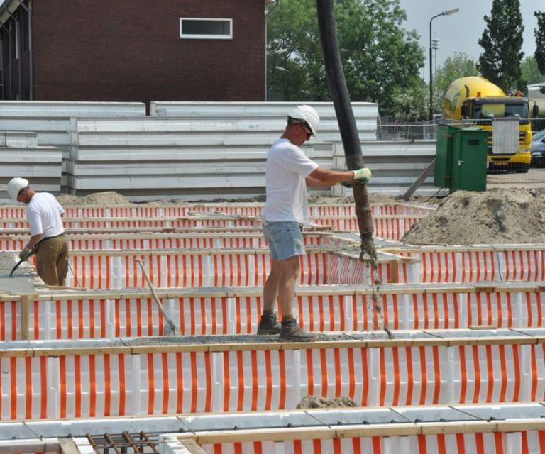Projectfoto van verwerkers die beton in de PowerKist funderingbekisting storten. 