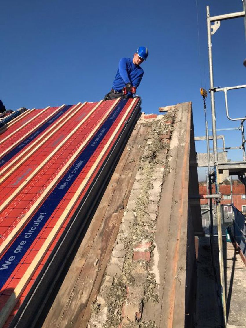 Projectfoto van een dakdekker die vanaf de nok een SlimFix dakplaat bevestigd op een oud dakbeschot.