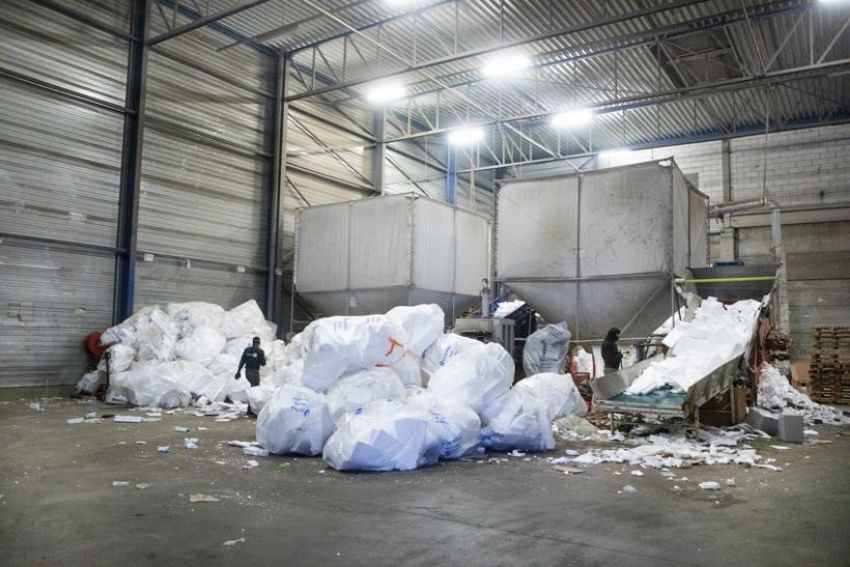 Foto van een fabriekshal waar witte EPS in recyclezakken wordt verzameld en gerecycled. 