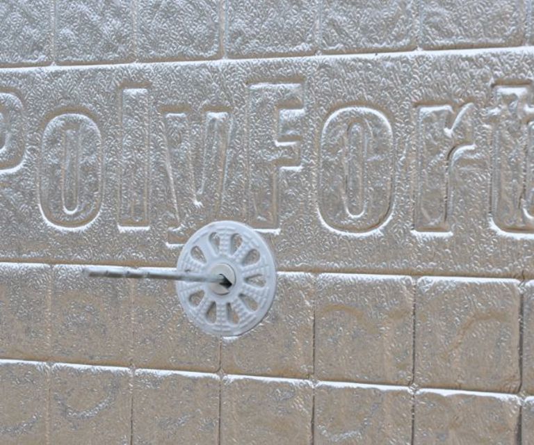 Close-up van een anker in de PolyFort Pro spouwisolatieplaat met thermische reflecterende cachering.