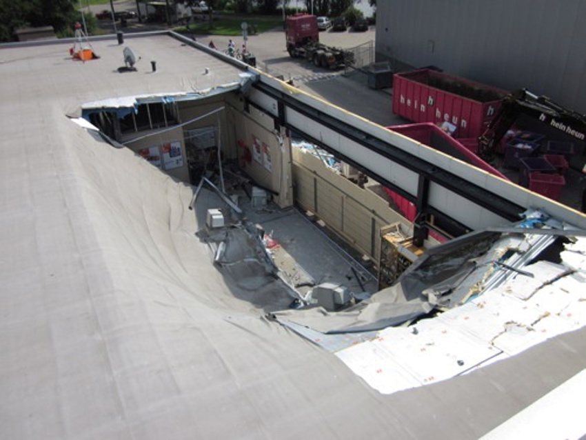 Foto van een plat dak wat gedeeltelijk is ingestort door wateraccumulatie door gebrek aan waterafvoer.