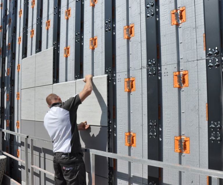 Projectfoto van een man die gevelbekleding monteert op het SlimFort gevelisolatiesysteem.