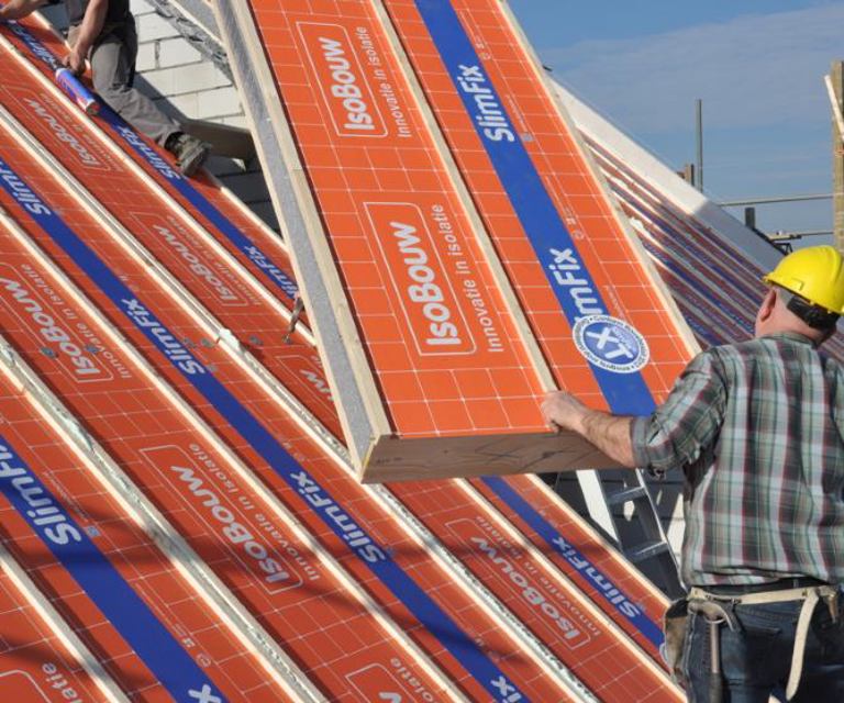 Projectfoto van een SlimFix XT dakplaat die gelegd wordt op het dak naast de andere isolatieplaten. 