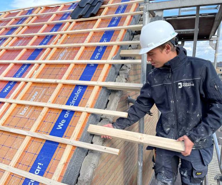 Projectfoto van een dakdekker die balken in de overstekvoorziening plaatst bij de SlimFix RenoTwin.