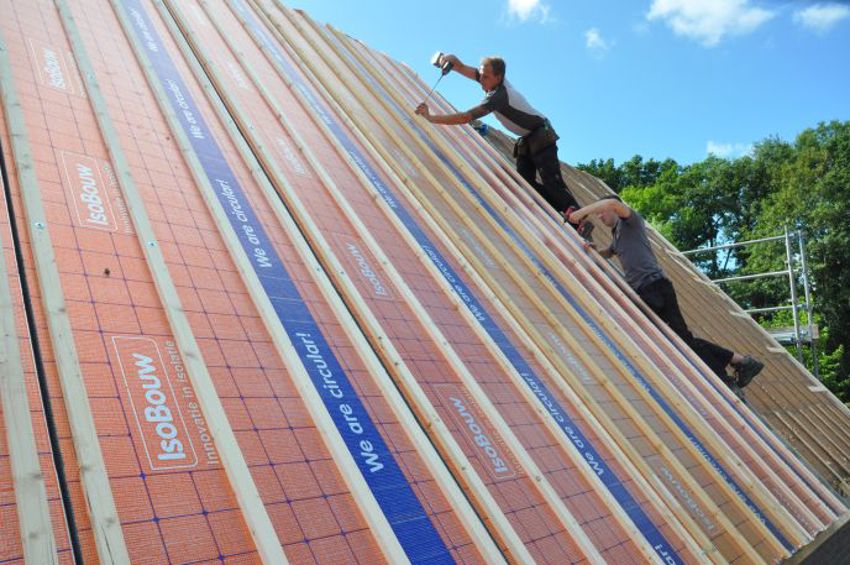 Projectfoto van dakdekkers die SlimFix RenoTwin dakisolatieplaten aan het bevestigen zijn. 