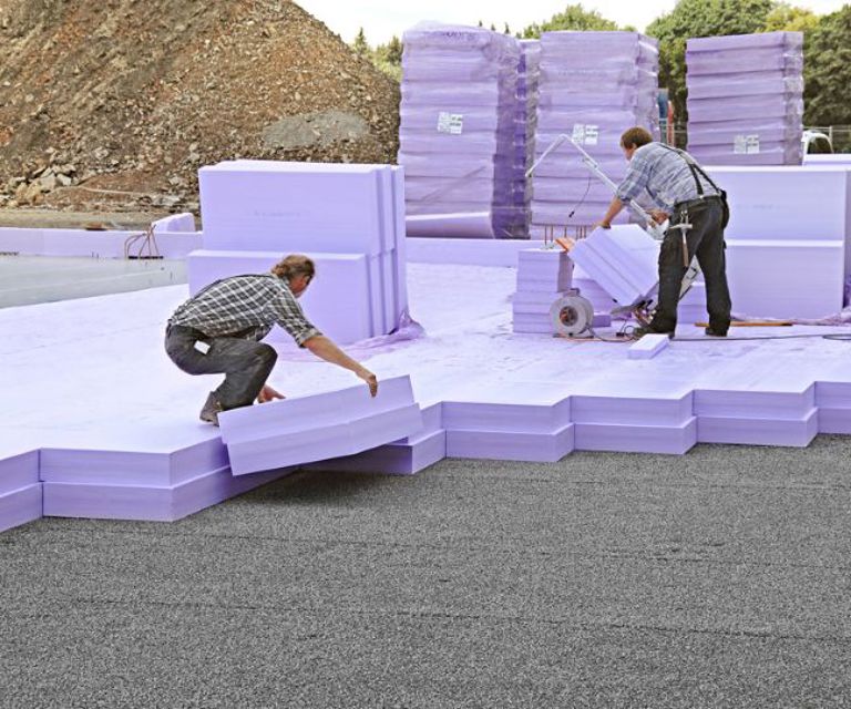 Projectfoto van verwerkers die XPS Jackodur isolatieplaten op de bouwplaats leggen. 
