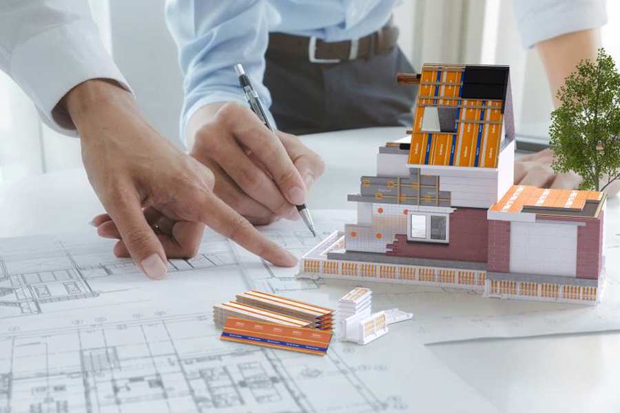 Afbeelding van 2 personen bij een bouwtekening en maquette van BEWI IsoBouw producten